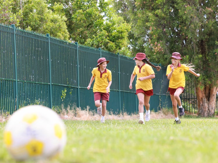 Students playing soccer, smiling