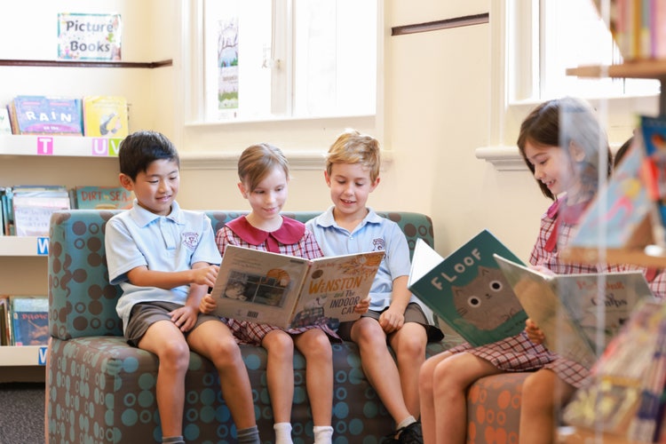 Students sitting in library reading books