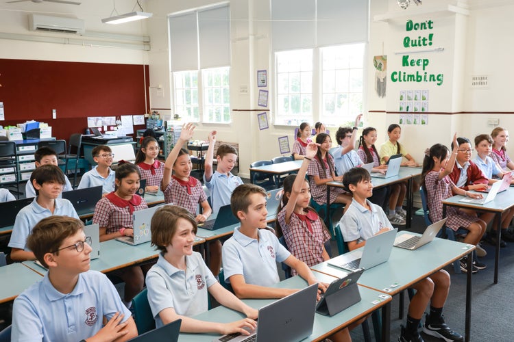 Students in a classroom at their desks with laptops